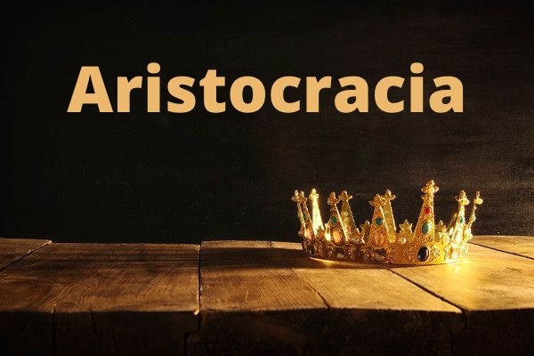 Coroa dourada sobre superfície de madeira e acima o escrito "Aristocracia".