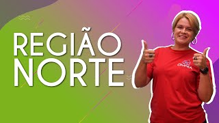 "Região Norte" escrito sobre fundo colorido ao lado da imagem da professora
