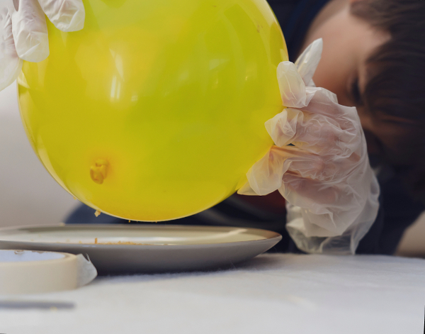 Na figura, o balão foi eletrizado por atrito e então atrai pequenos pedaços de papel.
