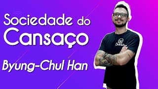 Professor ao lado do texto"Sociedade do Cansaço – Byung-Chul Han"em fundo roxo.