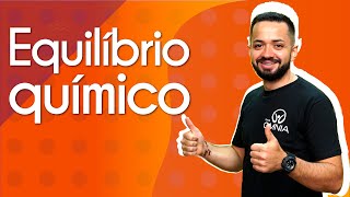 "Equilíbrio químico" escrito sobre fundo alaranjando ao lado da imagem do professor