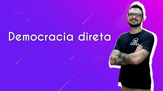 "Democracia direta" escrito sobre fundo roxo ao lado da imagem do professor