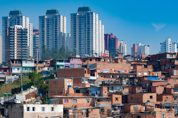 Faceta visível da segregação espacial entre ricos e pobres: Favela de Paraisópolis circundada por condomínios luxuosos, São Paulo.