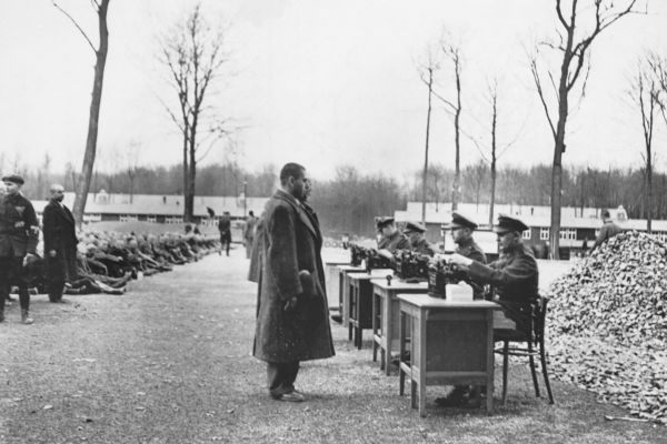 Funcionários da Gestapo trabalhando no registro de prisioneiros de campos de concentração.