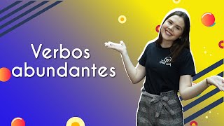 "Verbos abundantes" escrito sobre fundo colorido ao lado da imagem da professora