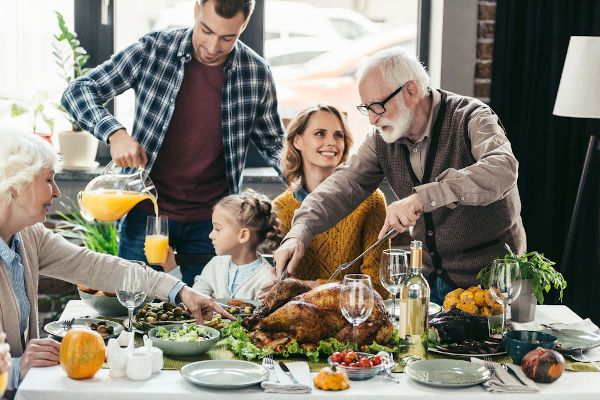 Família fazendo uma refeição em referência ao Dia de Ações de Graças, data que antecede a black friday.