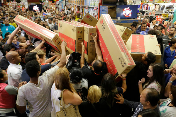 Multidão em uma loja de eletrodomésticos em referência à black friday.