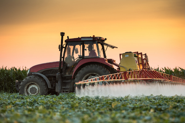 Máquina agrícola pulverizando agentes químicos. A tecnologia é uma das características da Revolução Verde.