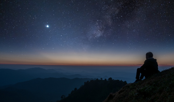 Homem observando o céu estrelado em alusão aos pontos cardeais.