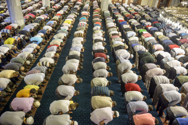 Muçulmanos ajoelhados em uma mesquita fazendo orações durante o Ramadã.