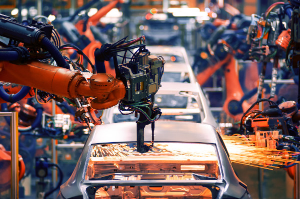 Foto de uma fábrica de carros com uma máquina funcionando.