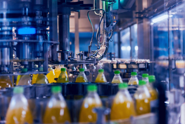 Foto de uma fábrica de bebidas na sua linha de produção.