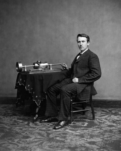 Thomas Edison sentado ao lado de um fonógrafo