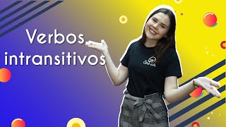"Verbos intransitivos" escrito sobre fundo colorido ao lado da imagem da professora