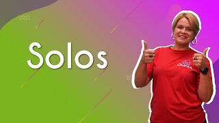 Professora ao lado do texto"Solos".