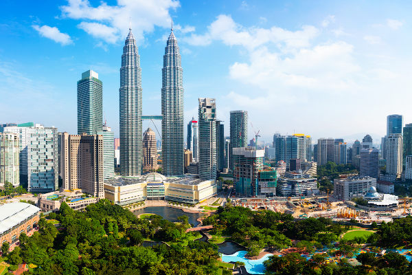 Vista de vegetação, de prédios e do céu em Kuala Lumpur, na Malásia