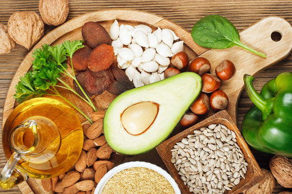 Alimentos ricos em vitamina E sobre uma mesa de madeira.