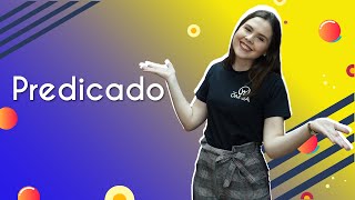 Professora ao lado do texto"Predicado".