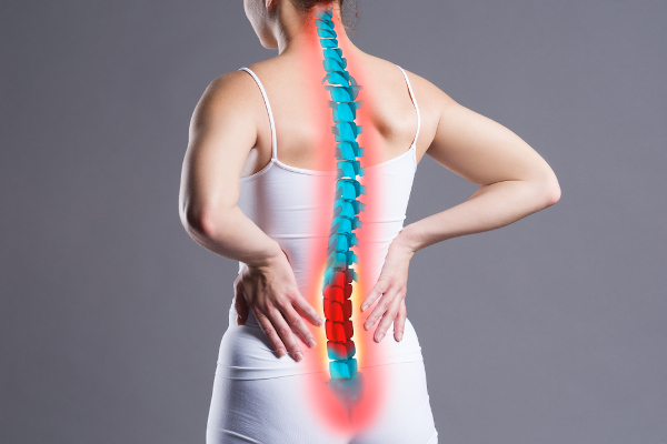 Mulher com as mãos nas costas e com a coluna vertebral ilustrativamente destacada para indicar o local da hérnia de disco.