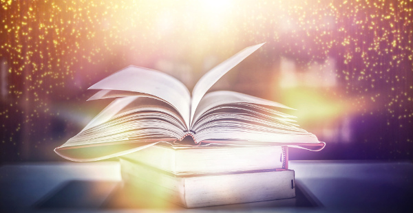 Livro aberto com efeitos brilhantes ao seu redor representando a ideia do mundo que se abre por meio da leitura.