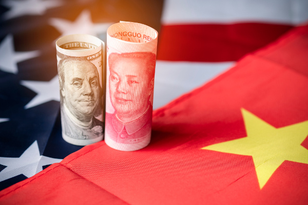 Moedas da China e dos Estados Unidos sobre as bandeiras de ambos