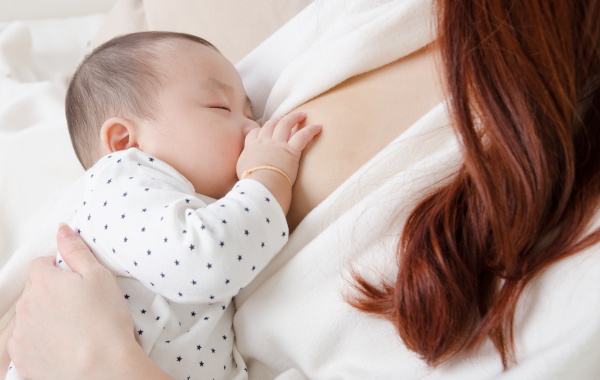 Amamentação de uma criança com leite materno, produzido nas glândulas que existem nas mamas.