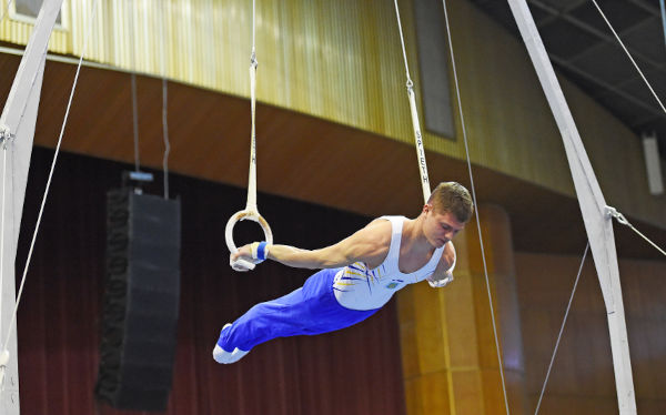 Atleta realizando movimento estático na horizontal na prova de argolas.