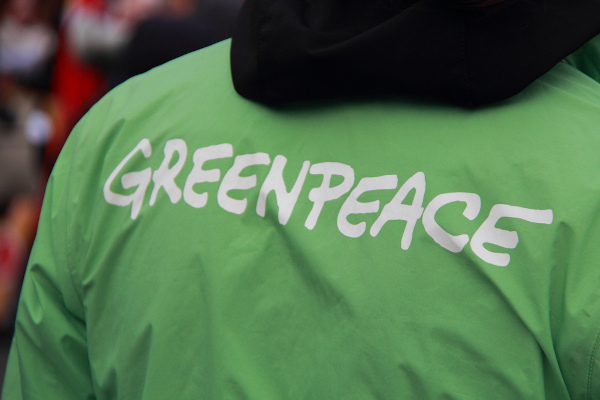 Pessoa vestida com camiseta verde, na qual está escrito: “Greenpeace”.