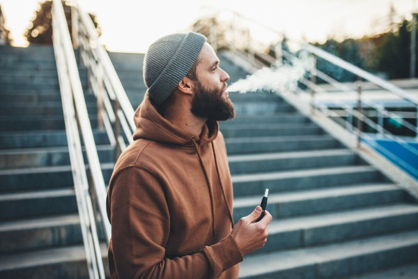 Homem fumando um cigarro eletrônico.