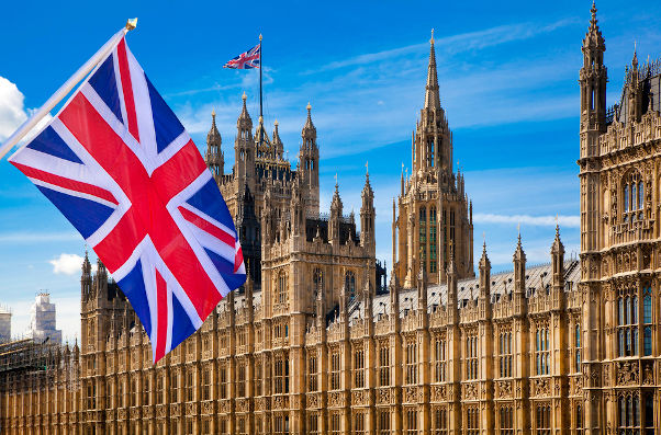 Fotografia do Parlamento britânico com a bandeira da Inglaterra em primeiro plano