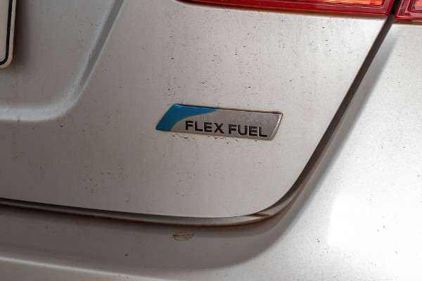 Vista aproximada de um adesivo com o escrito “flex fluel” em um carro flex.