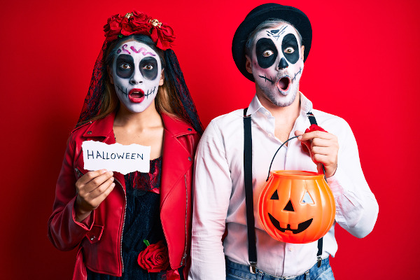 Casal com rosto pintado de caveira, uma das principais fantasias utilizadas no Halloween.