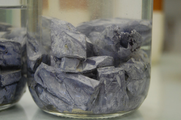 Pedaços do metal potássio, um metal alcalino, postos em óleo mineral para não reagir.