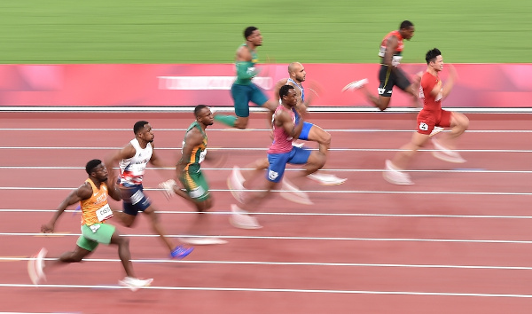 Atletas olímpicos correndo em pista olímpica.