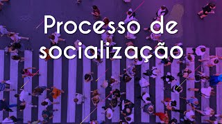 Texto "Processo de socialização" em um fundo roxo e uma faixa de pedestre com diversas pessoas atravessando.
