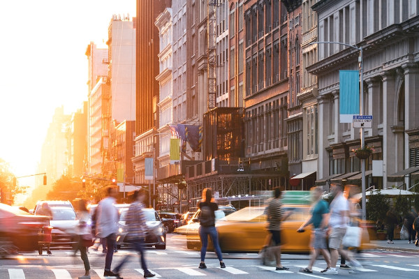 Pessoas passando por faixa de pedestres em avenida movimentada: exemplo de paisagem cultural.