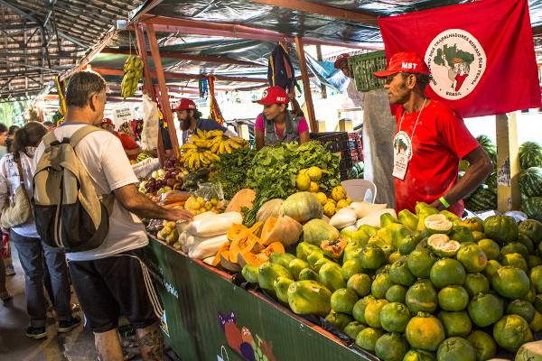 Pessoas do MST - Movimento dos Trabalhadores Rurais Sem Terra vendendo alimentos na feira.