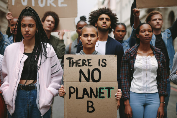Grupo de ativistas protesta contra a mudança climática. Há um cartaz, onde se lê: “There is no planet B”.