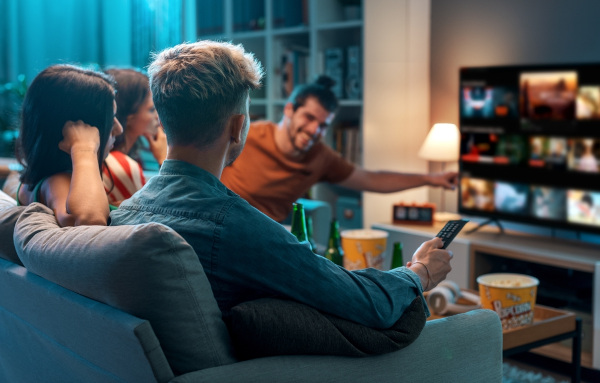 Amigos escolhendo filme como representação da importância do Ibope para os canais de televisão e serviços de streaming.