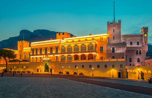 Palácio do Príncipe de Mônaco iluminado durante a noite.