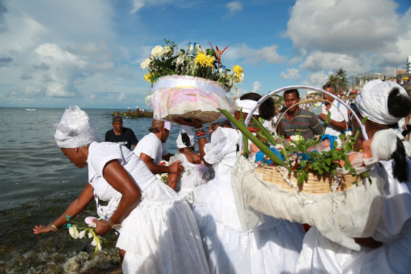 Devotos vestidos de branco na festa de Iemanjá, celebração cultural do Nordeste.