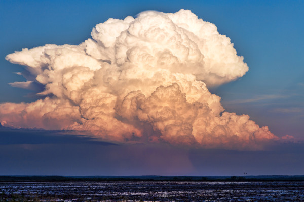 Vista de nuvens de tempestade, as cumulonimbus, um dos tipos de nuvem, em um céu azulado.