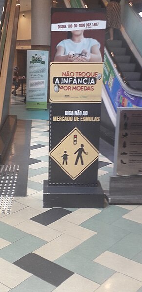 Cartaz em shopping com campanha contra esmolas, um exemplo de aporofobia.