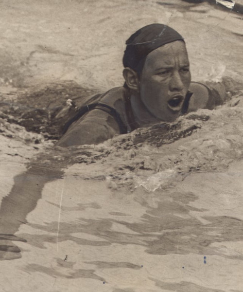 Foto antiga de Maria Lenk nadando em uma piscina.