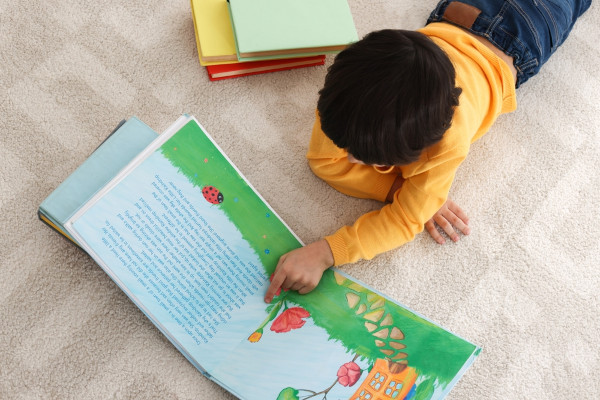 Criança lendo, em alusão ao Dia Nacional da Alfabetização.