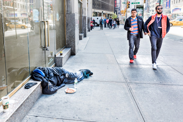Homem deitado em uma calçada de Nova Iorque, em texto sobre o american way of life.