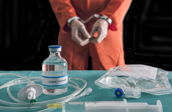Preso algemado próximo aos aparatos médicos que serão utilizados na execução de sua pena de morte por meio de injeção letal.