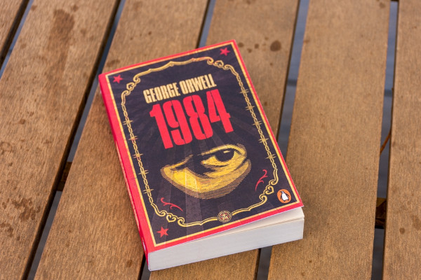 Livro “1984”, de George Orwell, sobre uma mesa de madeira.