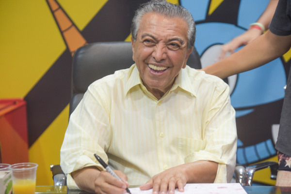 Mauricio de Sousa, autor e desenhista conhecido pelas histórias em quadrinhos “Turma da Mônica”, sorrindo ao dar autógrafo.