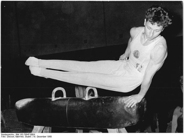 Na foto de 1960, um homem realiza movimento em cavalo com alças, um dos aparelhos da ginástica artística.